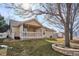 Tan house exterior with covered patio and landscaping at 9748 W Peakview Dr, Littleton, CO 80123