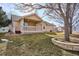 Tan house exterior with covered patio and landscaping at 9748 W Peakview Dr, Littleton, CO 80123