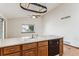 Kitchen island with sink and dishwasher; wood cabinets at 9748 W Peakview Dr, Littleton, CO 80123