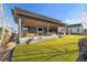 A view of the home's covered patio with outdoor living features, including a grill and patio seating at 6603 Canyonpoint Rd, Castle Pines, CO 80108