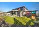 Beautifully landscaped backyard with covered patio, stone accents, and a play structure at 6603 Canyonpoint Rd, Castle Pines, CO 80108