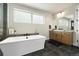 Bright bathroom with a soaking tub, contemporary vanity, and modern finishes at 6603 Canyonpoint Rd, Castle Pines, CO 80108