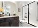 A modern bathroom features a walk in shower, dark wood vanity, and tiled floors at 6603 Canyonpoint Rd, Castle Pines, CO 80108