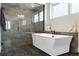 Modern bathroom featuring a soaking tub, glass-enclosed shower, and contemporary finishes at 6603 Canyonpoint Rd, Castle Pines, CO 80108