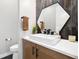 This bathroom has modern fixtures, with dark and light accents and a geometric mirror at 6603 Canyonpoint Rd, Castle Pines, CO 80108