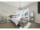 A stylish bedroom features a chandelier, large mirror and lots of natural light at 6603 Canyonpoint Rd, Castle Pines, CO 80108