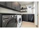 Well-organized laundry room with sleek cabinetry, modern appliances, and ample counter space at 6603 Canyonpoint Rd, Castle Pines, CO 80108