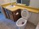 Bathroom features a vanity with yellow countertops, large mirror, and toilet with a decorative seat at 17900 E Asbury Dr, Aurora, CO 80013