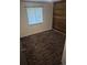 Bedroom features a window, brown patterned carpet, and wood accent wall at 17900 E Asbury Dr, Aurora, CO 80013