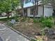 Exterior shot of the residence showing the side entrance framed by trees, bushes, and partial brick facade at 17900 E Asbury Dr, Aurora, CO 80013