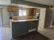 Updated kitchen features tile floors, stainless refrigerator, wood cabinets, and breakfast bar at 17900 E Asbury Dr, Aurora, CO 80013