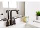 Close up on bathroom's black faucet and bright white countertop and sink at 6985 Braun Ct, Arvada, CO 80004