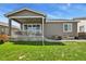 Home exterior showing covered porch and small patio area in a green lawn backyard at 16099 Alberta Dr, Parker, CO 80134