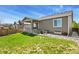 Home exterior showing covered porch and small patio area in a green lawn backyard at 16099 Alberta Dr, Parker, CO 80134