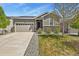 Charming single-story home featuring a two car garage, stone accents, manicured lawn, and solar panels at 16099 Alberta Dr, Parker, CO 80134