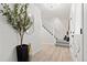 Bright entryway with light wood floors, white walls, decorative mirror, and staircase at 4102 W Union Ave, Denver, CO 80236