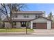 Inviting home features a modern garage door, covered porch, and fresh landscaping at 4102 W Union Ave, Denver, CO 80236