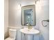 Charming bathroom featuring a pedestal sink, decorative mirror, and modern lighting fixtures at 4258 Tennyson St # 101, Denver, CO 80212