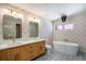 Elegant bathroom with a double vanity, standalone tub, and stylish patterned wallpaper at 4258 Tennyson St # 101, Denver, CO 80212