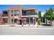 Modern mixed-use building with red brick and natural wood facade, balcony, and street-level commercial space at 4258 Tennyson St # 101, Denver, CO 80212