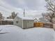 Backyard features a detached garage, surrounded by a wooden fence and a light dusting of snow at 4844 Vallejo St, Denver, CO 80221