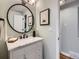 A powder room is decorated with a modern, round mirror, and features attractive fixtures at 4844 Vallejo St, Denver, CO 80221