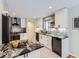 Bright kitchen features white cabinetry, stainless appliances and black and white patterned tile floors at 4844 Vallejo St, Denver, CO 80221