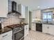 Well-lit kitchen boasting stainless steel appliances, white cabinets and a black backsplash at 4844 Vallejo St, Denver, CO 80221