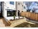 This is a shot of a home's backyard with a concrete patio, grass, and a wooden retaining wall at 421 S Pearl St, Denver, CO 80209