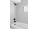 Bright bathroom showing a sleek shower and tub combo, matte black fixtures, and light, vertically laid tile at 421 S Pearl St, Denver, CO 80209