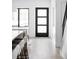 Bright hallway featuring a modern door with glass panels, wood flooring, and staircase at 421 S Pearl St, Denver, CO 80209