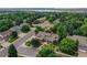 An aerial view shows the home nestled among lush trees in a friendly neighborhood with a large lake nearby at 8160 W Phillips W Ave, Littleton, CO 80128