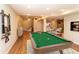 Finished basement rec room with pool table, stairs, and laminate flooring at 8160 W Phillips Ave, Littleton, CO 80128