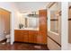 Modern bathroom with double vanity, sleek cabinetry, and tiled shower with glass partition door at 8160 W Phillips Ave, Littleton, CO 80128