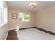 Bright bedroom features wood floors, white trim, a beige rug, and a view of mature trees at 8160 W Phillips W Ave, Littleton, CO 80128