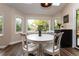 Bright breakfast nook features a white table, chairs, large windows, and sleek hardwood floors at 8160 W Phillips W Ave, Littleton, CO 80128