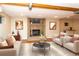 Staged living room features fireplace, laminate floors, and neutral-tone walls at 8160 W Phillips Ave, Littleton, CO 80128
