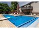 A sparkling pool includes a diving board and water feature, set against a backdrop of mature trees at 8160 W Phillips W Ave, Littleton, CO 80128