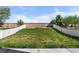 Spacious, grassy backyard enclosed by a white fence, perfect for outdoor activities at 10778 Dayton Way, Commerce City, CO 80640