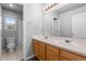 This bathroom features a double sink, a large mirror, a toilet, and a shower with a window at 10778 Dayton Way, Commerce City, CO 80640