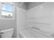 This bathroom features a toilet, shower/tub combo, and a window bringing in natural light at 10778 Dayton Way, Commerce City, CO 80640