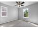 This bedroom features neutral walls, carpet, a ceiling fan, and bright, natural light from the two windows at 10778 Dayton Way, Commerce City, CO 80640
