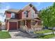Charming two-story home with a covered front porch and a well-manicured lawn at 10778 Dayton Way, Commerce City, CO 80640