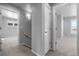 A hallway featuring neutral walls, carpet, baseboards, and two open doorways with one closed door at 10778 Dayton Way, Commerce City, CO 80640