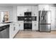 Bright kitchen featuring stainless steel appliances, white cabinets, modern countertops, and hardwood floors at 10778 Dayton Way, Commerce City, CO 80640