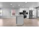 Modern kitchen featuring stainless steel appliances, white cabinets, and a center island with bar seating at 10778 Dayton Way, Commerce City, CO 80640