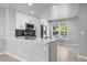 Modern kitchen with island, stainless appliances, stone countertops, and dark backsplash at 10778 Dayton Way, Commerce City, CO 80640
