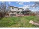 Spacious backyard with lush green lawn, hot tub, outdoor dining and seating areas, with a beautiful pergola at 5986 Dunraven Ct, Golden, CO 80403