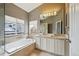 Luxurious bathroom featuring a soaking tub, double vanities, and a separate shower, creating a spa-like experience in your own home at 5986 Dunraven Ct, Golden, CO 80403
