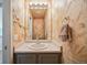 Charming powder room featuring textured walls, ample lighting, and a stylish vanity, creating a unique and inviting space at 5986 Dunraven Ct, Golden, CO 80403
